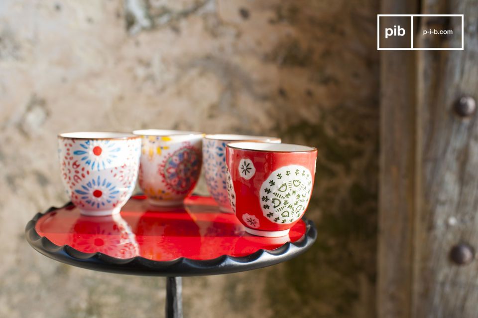 Quatre tasses sans anse en céramique aux motifs floraux.