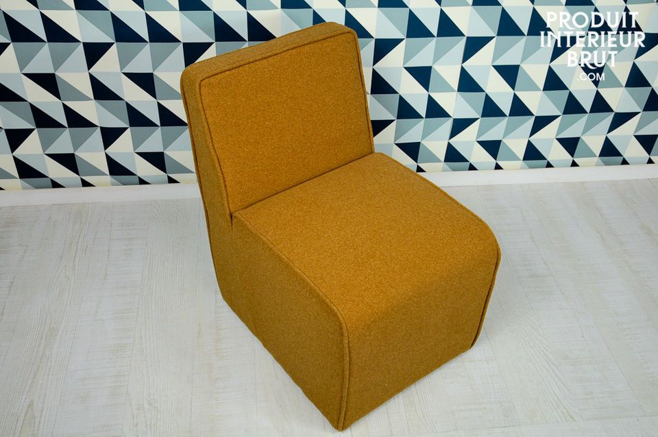 La couleur ocre de la feutrine dont ce fauteuil est couvert participe à son look fifties