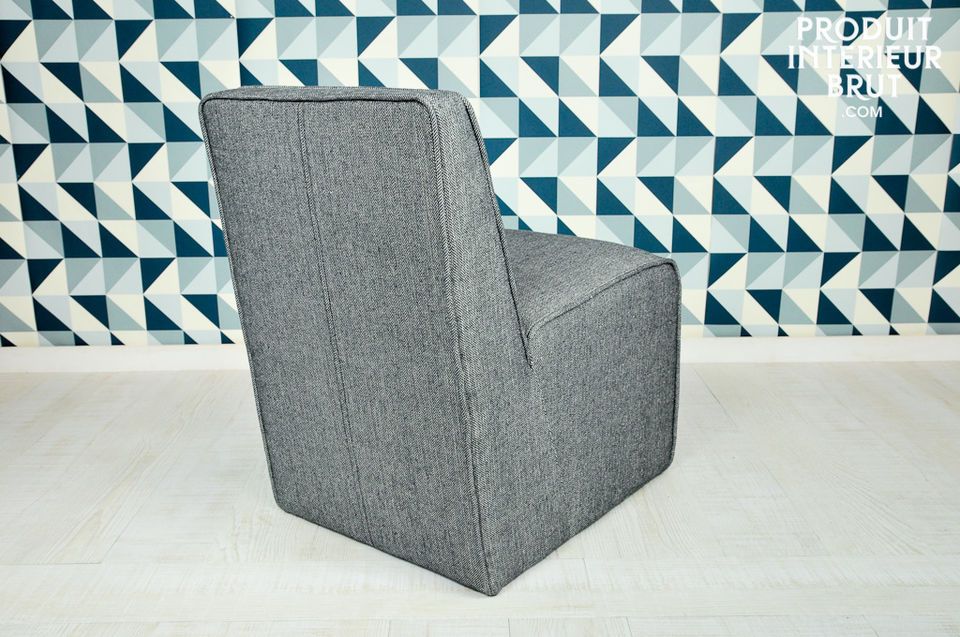Le tissu gris dont ce fauteuil est couvert participe à son look fifties