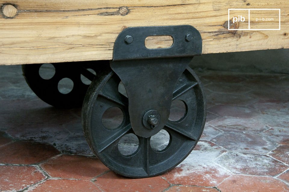la table est réalisée dans un bois épais verni, et monté sur des roues en fonte.