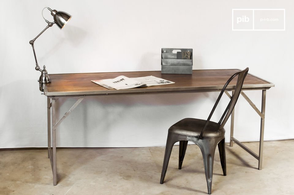 Table industrielle accompagnée par chaise, lampe et objets rétro.