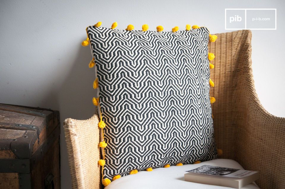 Élégant coussin noir et blanc à pompons jaune.