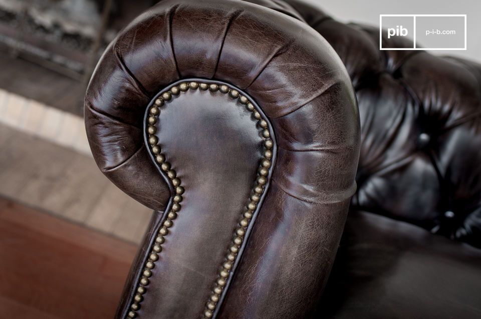 Les accoudoirs de ce canapé sont tapissés d'une garniture en cuir cloutée