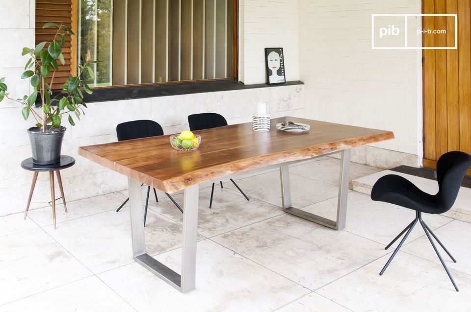 Grande table en bois clair et au piétement métallique angulaire.