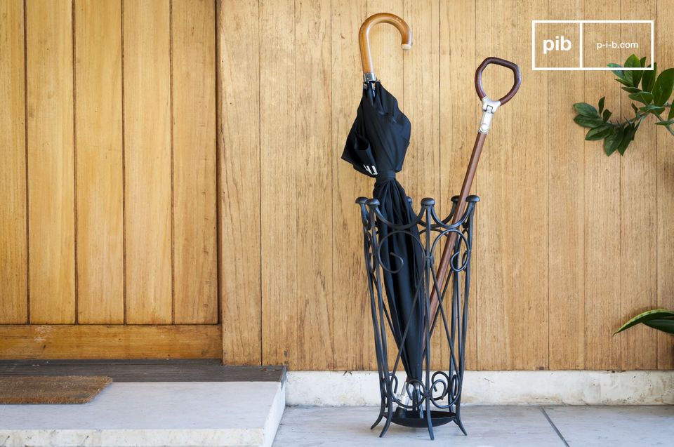 Un porte parapluie vintage en fer forgé noir.