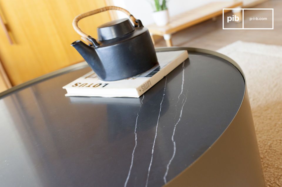 Le plateau en marbre noir nervuré de blanc est associé à une laque dorée.