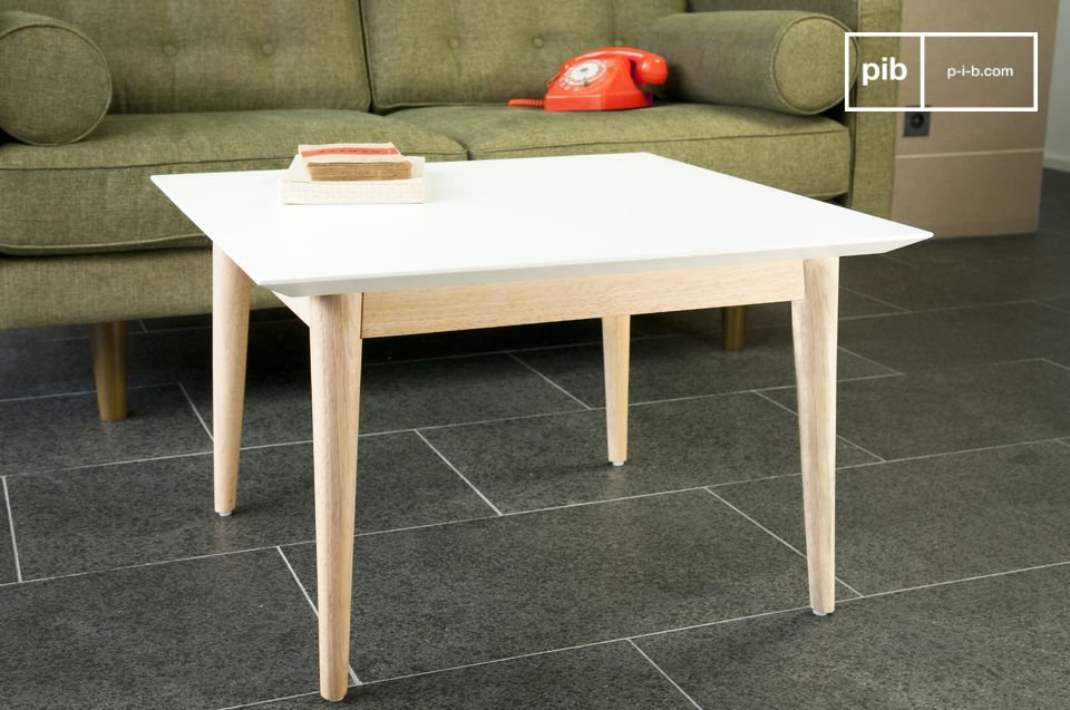 Table basse carrée au plateau blanc et au piétement en bois.