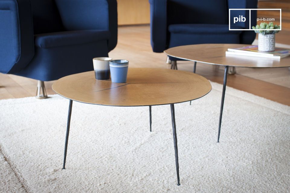 Table élégante en bois clair et au piétement en métal noir mat.