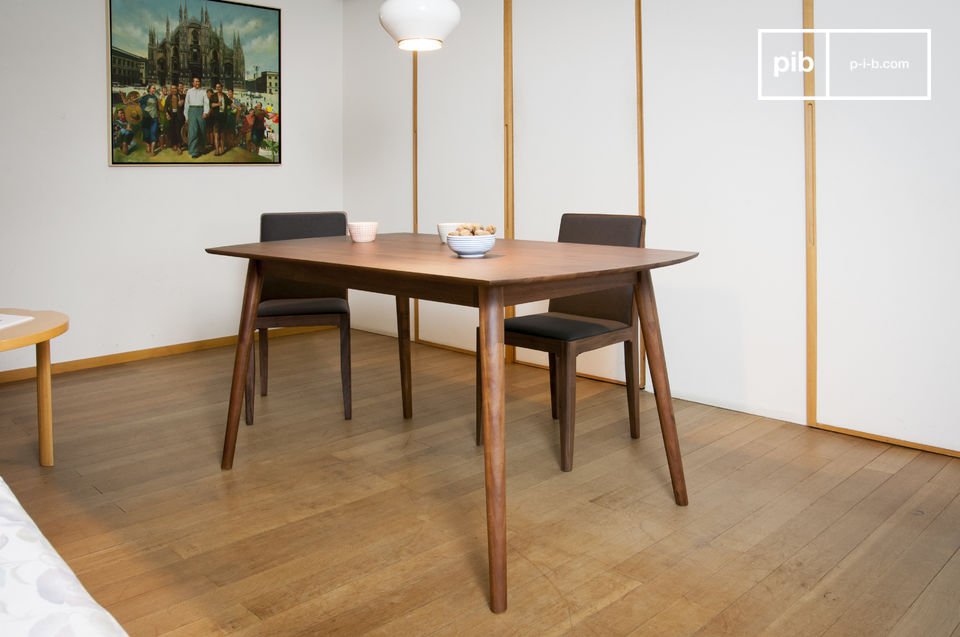 Belle table de repas en bois sombre et aux pieds compas.