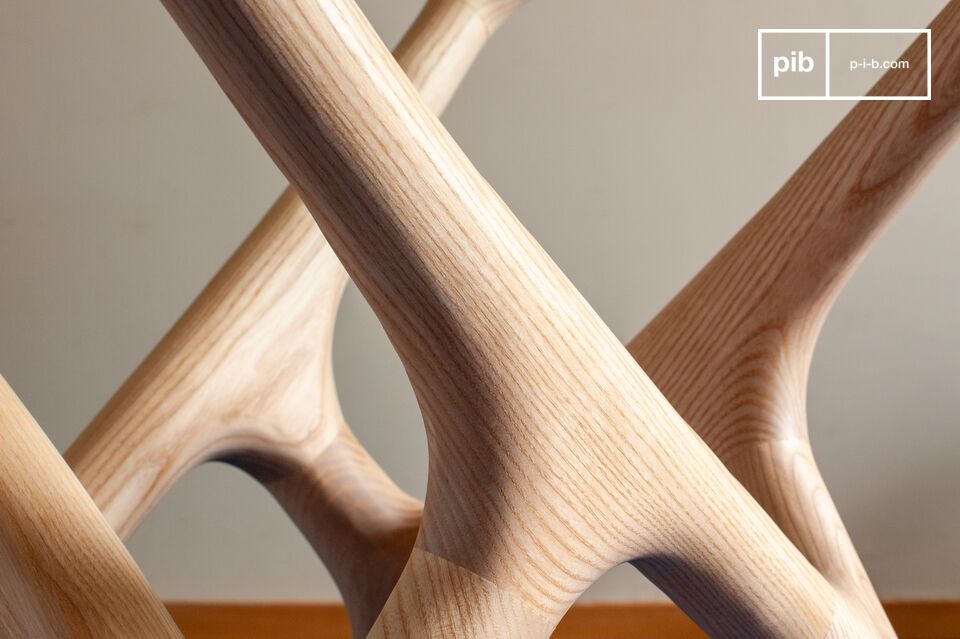 Son plateau en verre trempé repose sur un piètement sculpté dont la structure entrelacée